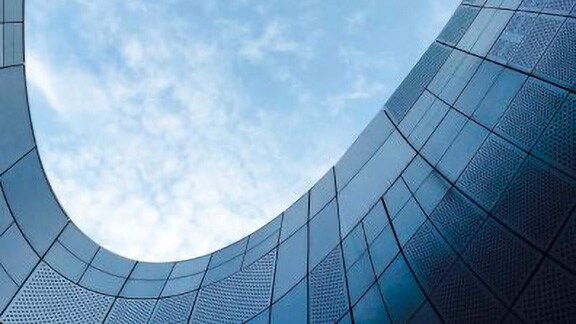 Close-up of the curved edge of a commercial building under the blue sky