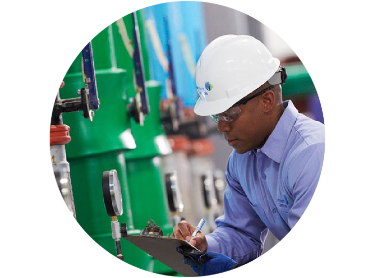 Man in a Johnson Controls hemet inspecting a piping system