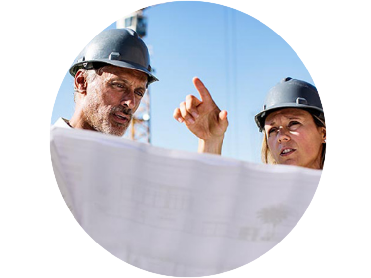 Two people in safety helmets holding a chart at a construction site within a circle